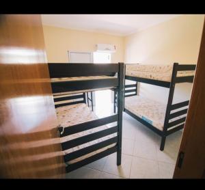 Cette chambre comprend 3 lits superposés et une porte. dans l'établissement Villaggio Avansi, à Caraguatatuba