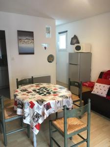 a room with a table and chairs and a refrigerator at Résidence les campenes in Les Rousses