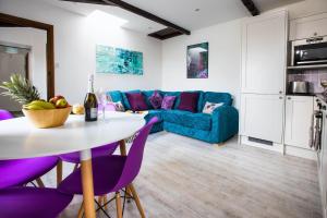 un soggiorno con tavolo e sedie viola di Lavender Cottage a Bude