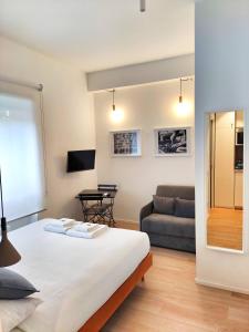 una camera da letto con un letto e un divano di E-Milan Rooms Zona Tortona a Milano