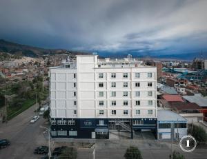 um grande edifício branco em frente a uma cidade em Hotel Unu em Huancayo