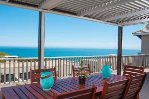 a dining room table with chairs and umbrellas at Brenton Haven Beachfront Resort in Brenton-on-Sea
