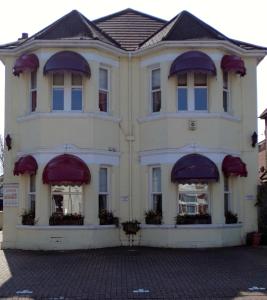 um grande edifício com toldos roxos em Hunters Lodge Guest House em Southampton