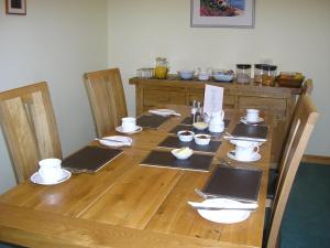 a wooden table with plates and dishes on it at Balhousie Farm Bed and Breakfast in Kirkton of Largo
