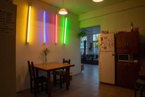Un comedor con una mesa y un refrigerador. en Pinamar Hostel Casa de Verano, en Pinamar