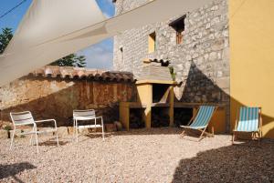 a group of chairs sitting in front of a building at Casa Rural La Fàbrega in Aiguamurcia