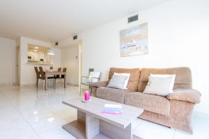 a living room with a couch and a table at Apart-rent Apartamento Francesc Macia 1º 2002 in Roses