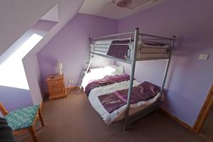 a bedroom with a bunk bed with purple walls at Ard Garraidh in Ardersier