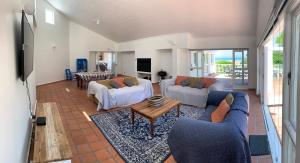 ein Wohnzimmer mit 2 Sofas und einem Tisch in der Unterkunft Southern Cross Beach House in Groot Brak Rivier