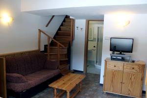 a living room with a couch and a tv and stairs at Chalet Presanella in Temù