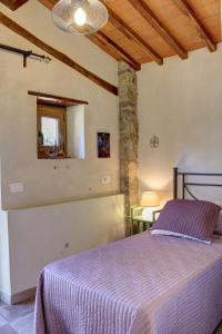 a bedroom with a bed with a purple blanket at Il Fienile in Figline Valdarno