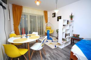 a small room with a table and chairs and a bed at B&M Apartment in Braşov