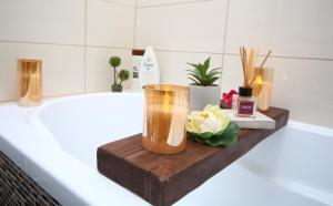 a bathroom with a bath tub with a candle and flowers at B&M Apartment in Braşov