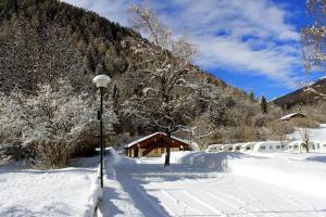 a street light in the snow next to a house at Chalet Presanella in Temù