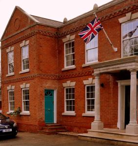 a red brick building with a british flag on it at Mandalay Holiday Home in Amesbury