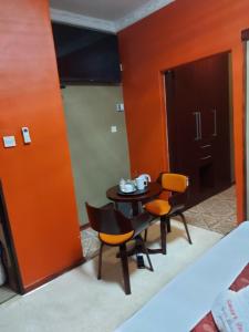 a room with a table and chairs and a door at SMART INN GUEST HOUSE in Jwaneng
