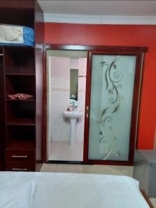 a bedroom with a bathroom with a sink and a mirror at SMART INN GUEST HOUSE in Jwaneng