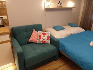 Zimmer mit 2 Betten, einem Sofa und einem Stuhl in der Unterkunft Willa Lazur in Ustka