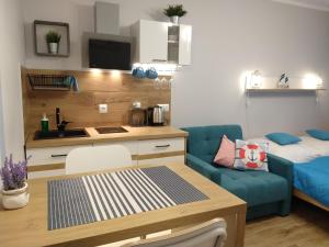 Apartamento pequeño con mesa y sofá azul en Willa Lazur, en Ustka