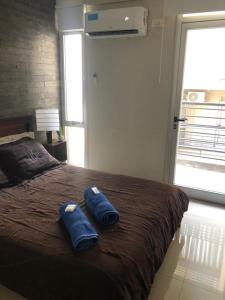 2 almohadas azules sentadas en una cama en un dormitorio en B and B Marcos Paz Apartment en San Miguel de Tucumán