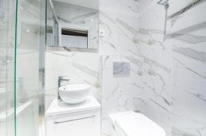 a white bathroom with a sink and a mirror at MBM - Marais in Paris