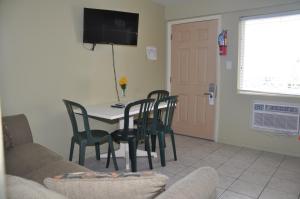 a living room with a table and chairs and a tv at Coliseum Ocean Resort in Wildwood Crest