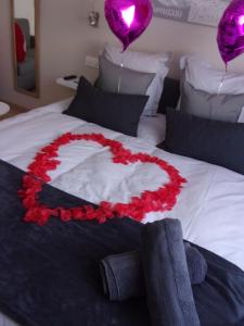 a bed with a heart made out of red roses at Le Bourget - Envolée Romantique in Narbonne