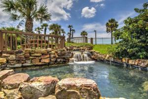 a backyard pool with a waterfall and a rock wall at Gulf View, Flip Flop Oasis GVR06432 in Galveston