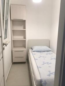 Dormitorio pequeño con cama y armario abierto en Villa Maria, en Zadar