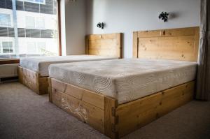 two wooden beds in a bedroom with a window at Studio Livia in Vysoke Tatry - Stary Smokovec