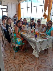 un grupo de personas sentadas en una mesa comiendo en Hospedaria Piramide Por Do Sol, en São Thomé das Letras
