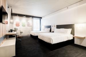 een hotelkamer met twee bedden en een bureau bij Alt Hotel Ottawa Downtown in Ottawa