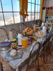 uma mesa com comida e bebidas em cima em Hospedaria Piramide Por Do Sol em São Tomé das Letras