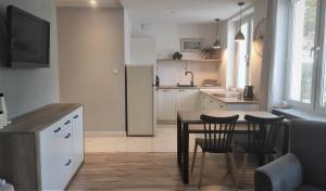 a kitchen with a table and chairs and a refrigerator at Jurata pod Sosnami in Jurata