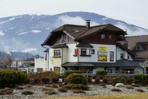 a large building with a mountain in the background at Pizzeria Restaurant Wieser in Rasùn di Sotto
