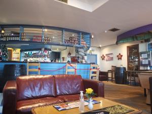 a living room with a leather couch and a bar at Marine Hotel in Buckie