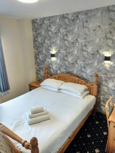 a bedroom with a bed with a gray and white wallpaper at Marine Hotel in Buckie