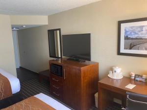 a hotel room with a flat screen tv and a desk at Comfort Inn in Springfield