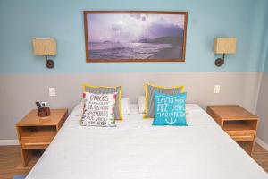 um quarto com uma cama com almofadas em Flat Privativo Reserva do Mar em Angra dos Reis