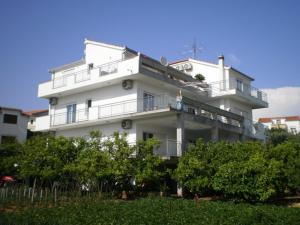 een groot wit huis met een balkon. bij Apartments Maslina in Trogir