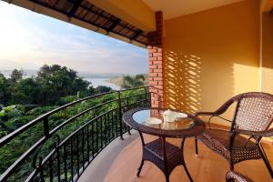 een balkon met 2 stoelen en een tafel met uitzicht bij Vista Del Lago in Ambalavayal