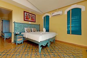 a bedroom with a bed with a blue and yellow wall at Vista Del Lago in Ambalavayal