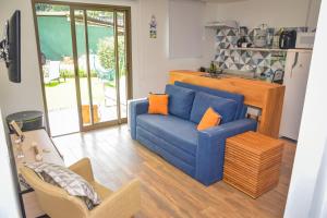 ein Wohnzimmer mit einer blauen Couch und einer Küche in der Unterkunft Flat Privativo Reserva do Mar in Angra dos Reis