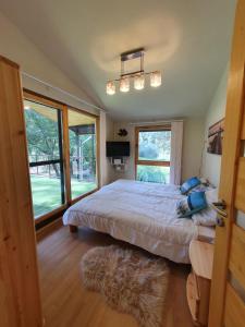 a bedroom with a bed and a large window at Bárka a Tiszához apartman in Tiszaug