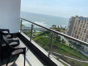 Un balcón con sillas y vistas al océano. en Terrazas Apartments Miraflores, en Lima