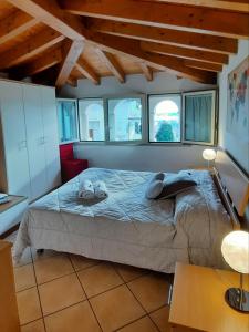 um quarto com uma cama num quarto com janelas em Appartamenti Esmera em Desenzano del Garda