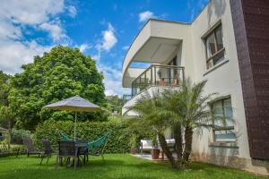 ein Haus mit einem Tisch und einem Sonnenschirm im Hof in der Unterkunft Flat Privativo Reserva do Mar in Angra dos Reis