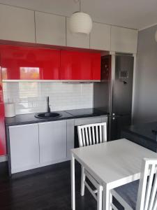 a kitchen with red and white cabinets and a table at Kawalerka wielki kack in Gdynia