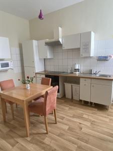 a small kitchen with a wooden table and chairs at Hafen 12 in Bremerhaven