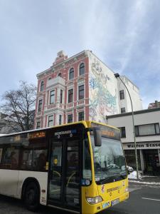 een gele en witte bus geparkeerd voor een gebouw bij Hafen 12 in Bremerhaven